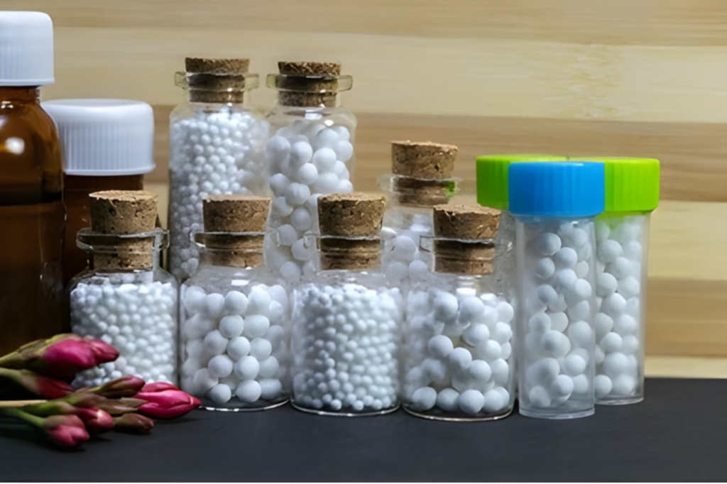 Homeopathic medicine globules in glass bottles and containers on a wooden background