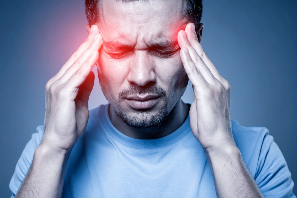 Man holding his head with red highlighted areas indicating severe headache or migraine pain